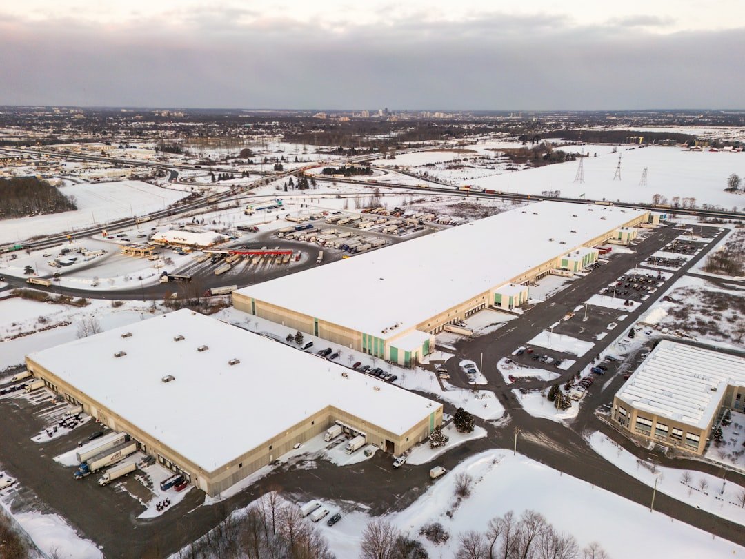 aerial-view-of-industrial-warehouses-covered-in-snow-weqfybt3q-c